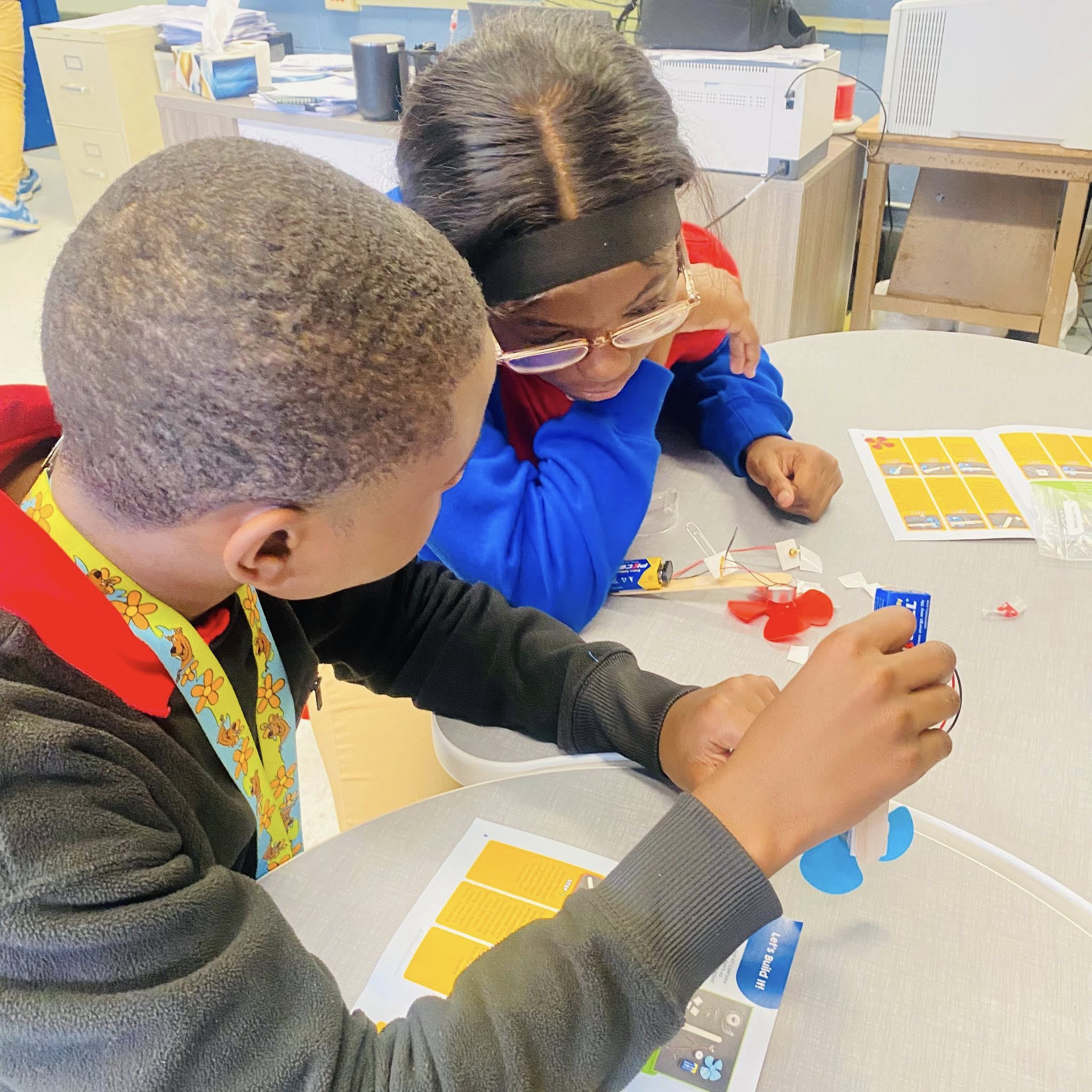 A girl and a boy looking at materials to make something.